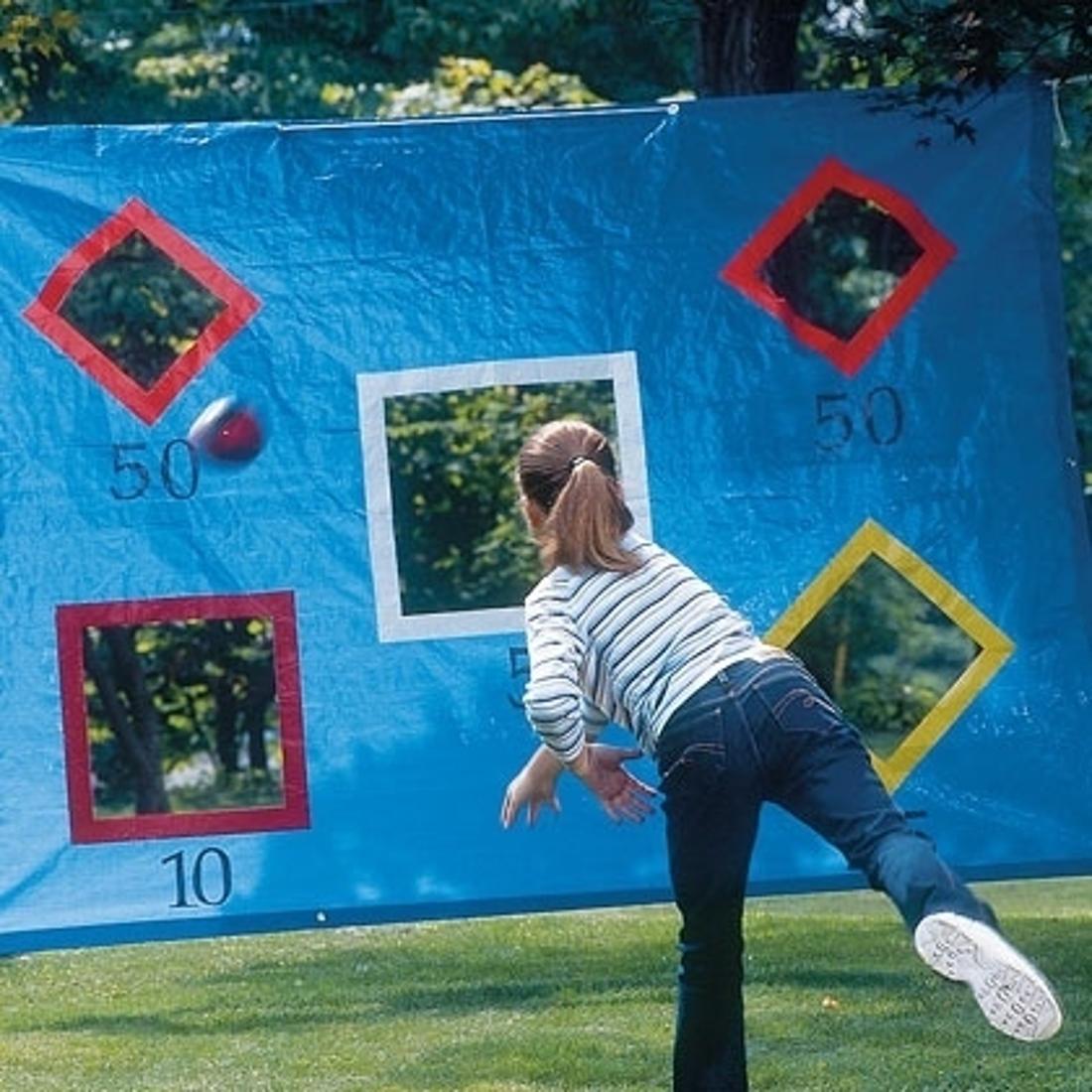 Hang a tarp between two trees and cut shapes out so the kids can practice their throwing motions.