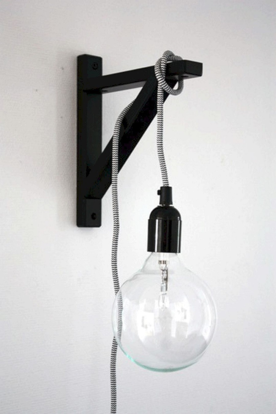 For a space-saving lamp, hang a lightbulb on a cord off of a wall-mounted shelf bracket.