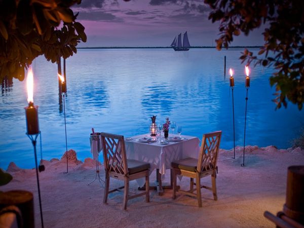 Torch-lit beach dinner with ocean views