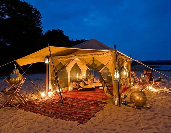 Traditional Bedouin beach tent with lanterns and outdoor dining