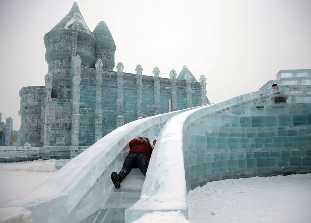 A woman rides a slide on an ice sculpture