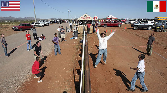 Residents Of Naco, Arizona, And Naco, Mexico Play Volleyball Match Over Fence Between USA And Mexico