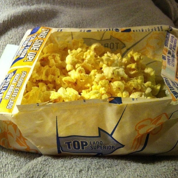 For more accessible access to the popcorn and to prevent reaching your hand into a greasy bag, try ripping a hole on the bag's surface instead of opening it the traditional way.