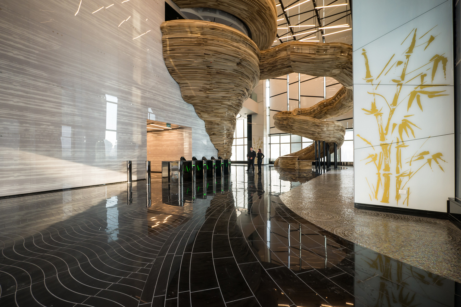The stair structure is composed of two sculptural elements: the spiraling stairs and a tornado-like element, which seem to emerge from the reflecting walls of the entrance lobby.