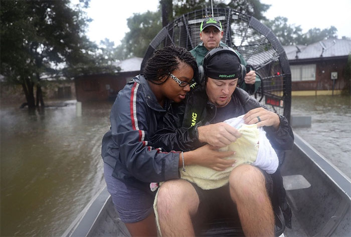 Shardea Harrison Looks At Her 3-week-old Baby, Sarai, As Dean Mize, Right, And Jason Legnon Use An Airboat To Rescue Them From Their Home In Houston