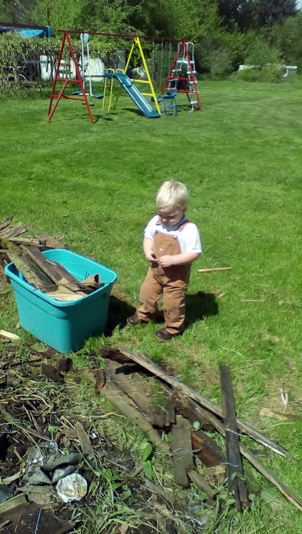 My 2-Year-Old Son Picking Loose Wood Up Around The Yard So His Papa Can Mow.