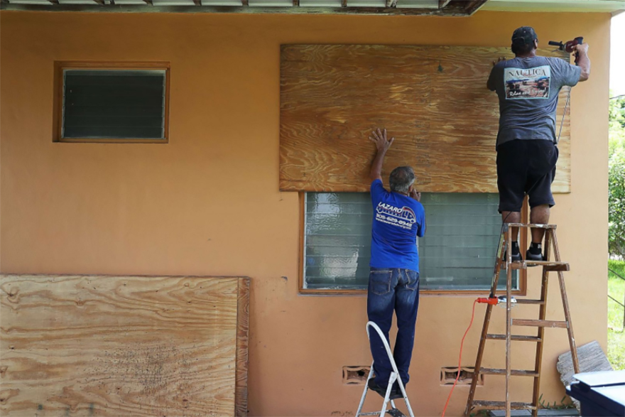 People Put Up Shutters As They Prepare A Family Member's House For Hurricane Irma
