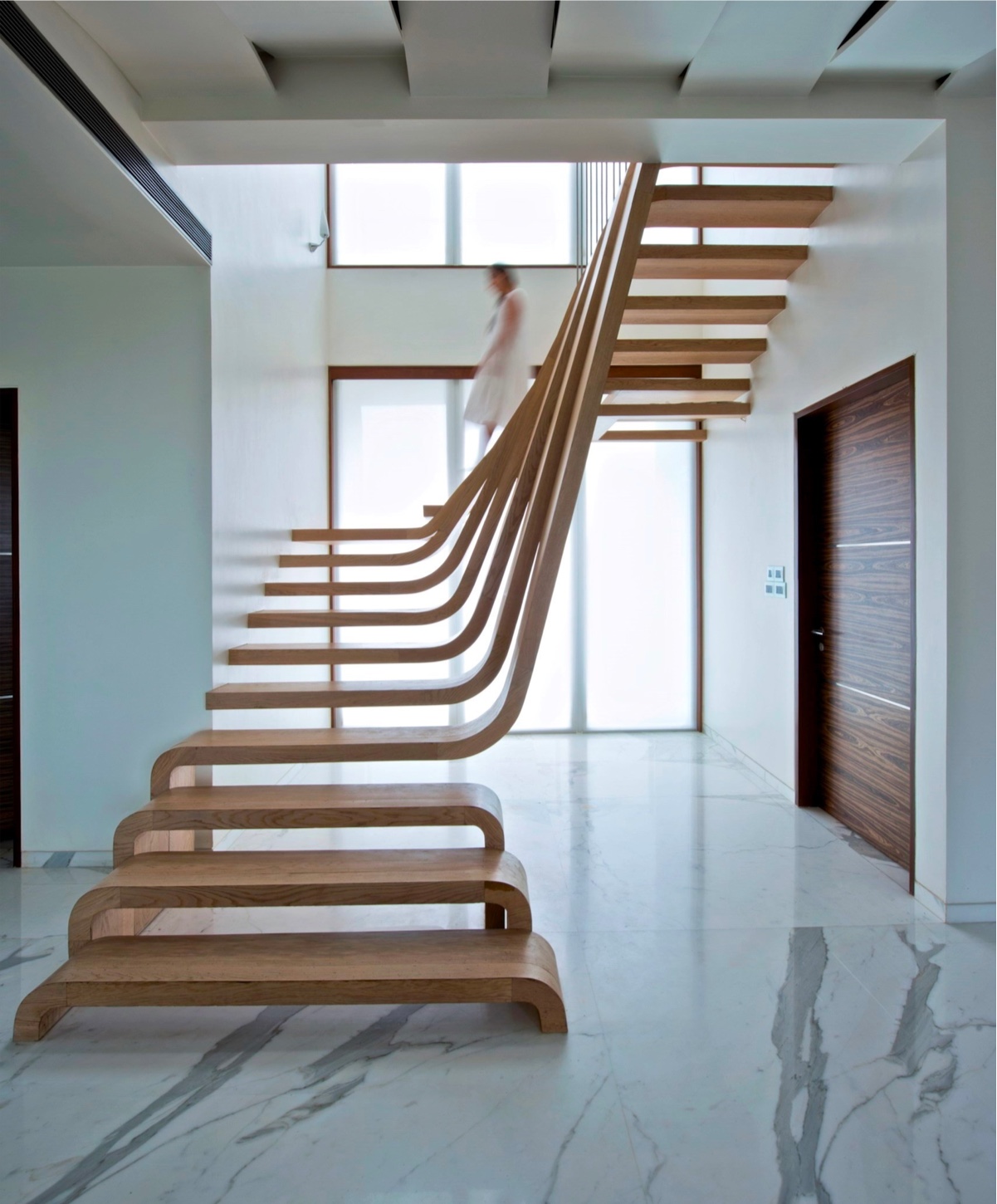 Get canny with curves. These wooden treads arc and slide between the upper and lower levels of the stairway to stunning effect.