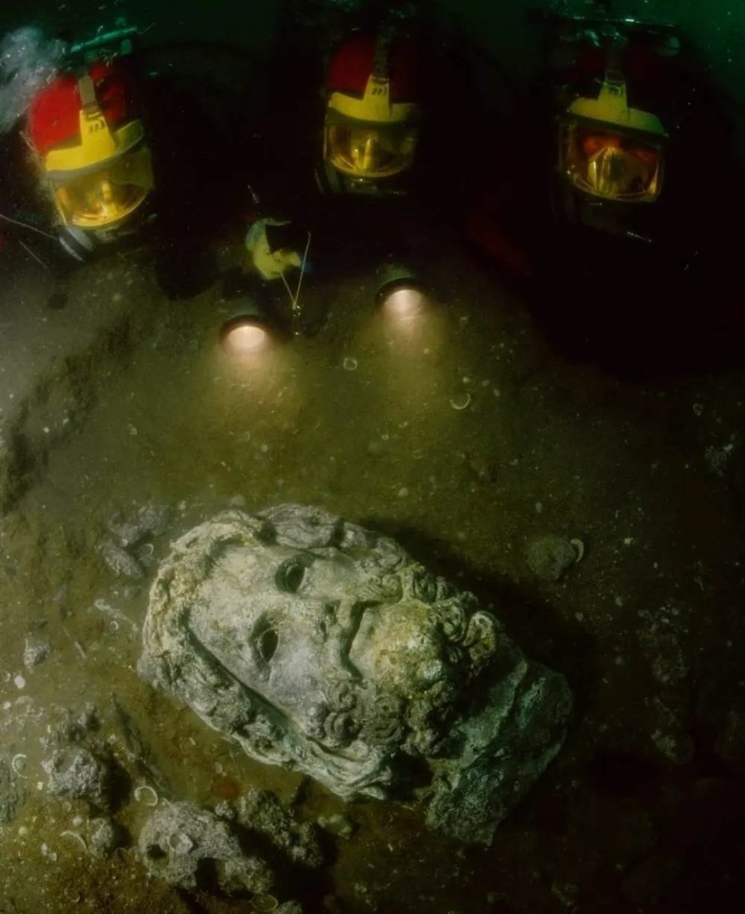 Divers Shining Lights On A Head Of Serapis, Found In The Sunken Egyptian Coastal Town Of Canopus