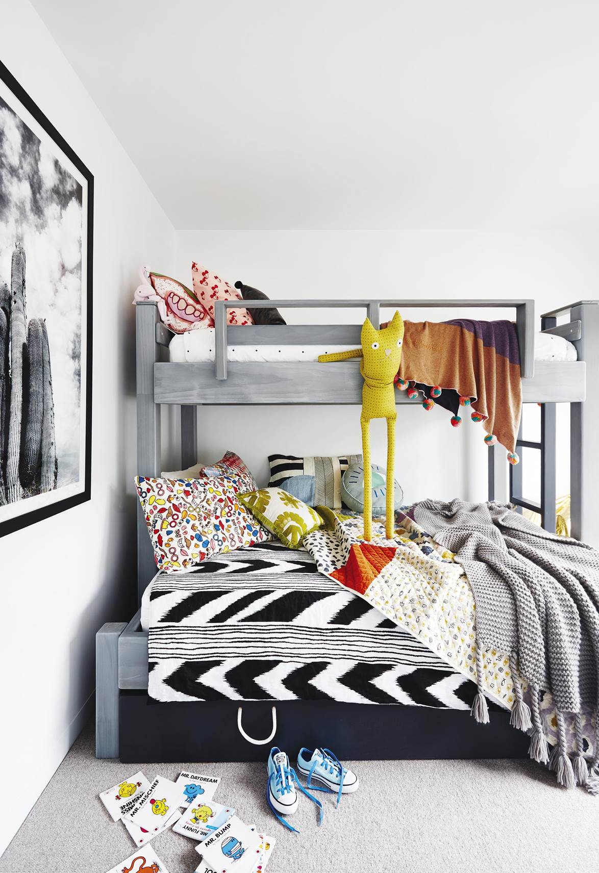 The kids' bedroom within a coastal abode features a bunk bed with a stowaway trundle. It maximizes space while fun, colorful furnishings create a comfy retreat for the kids.