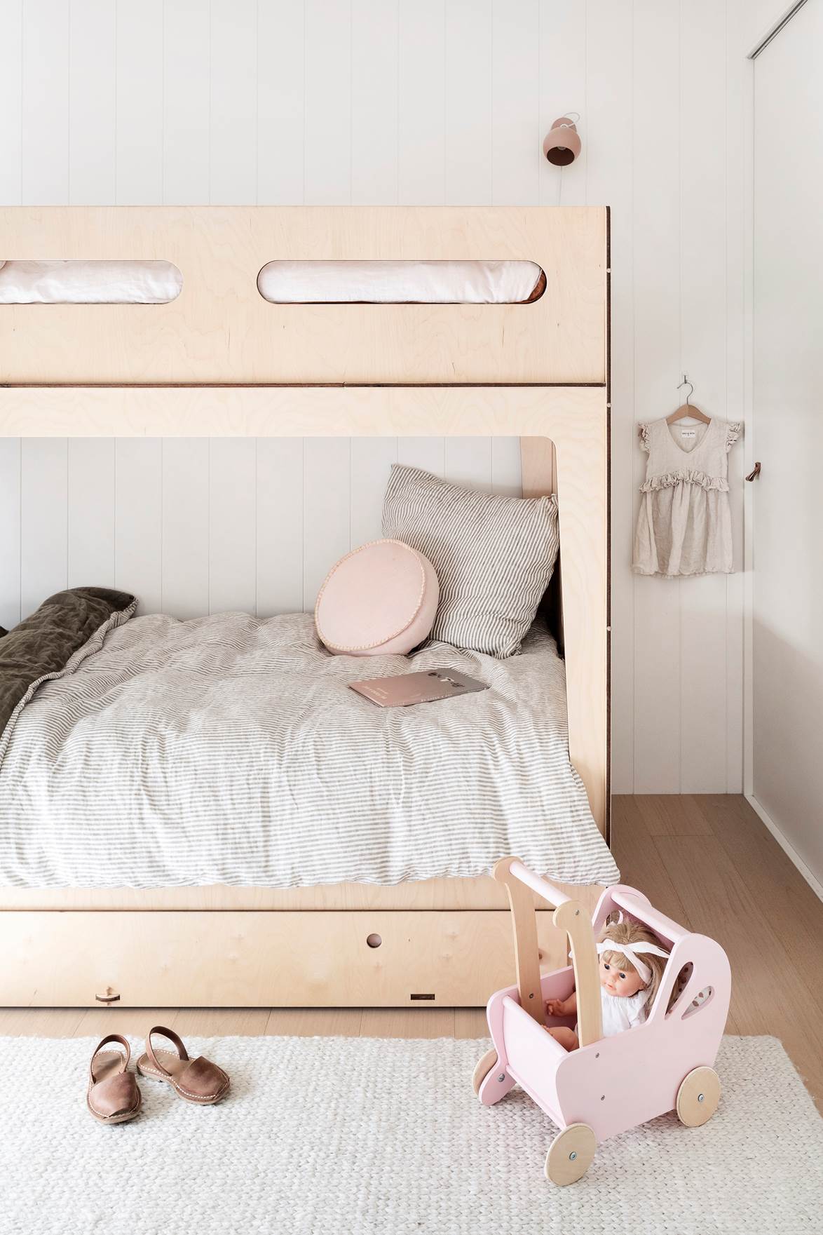 Inspired by the simplicity of the Scandinavian architecture and minimalist beach houses in New Zealand, this contemporary home's interiors are unassuming. "The palette is based on pale timbers, soft peachy tones, and warm whites, referencing the colors of the coastline," says owner Rebecca—Castello—bunk beds from Playroom tie in with the overall Scandi aesthetic.