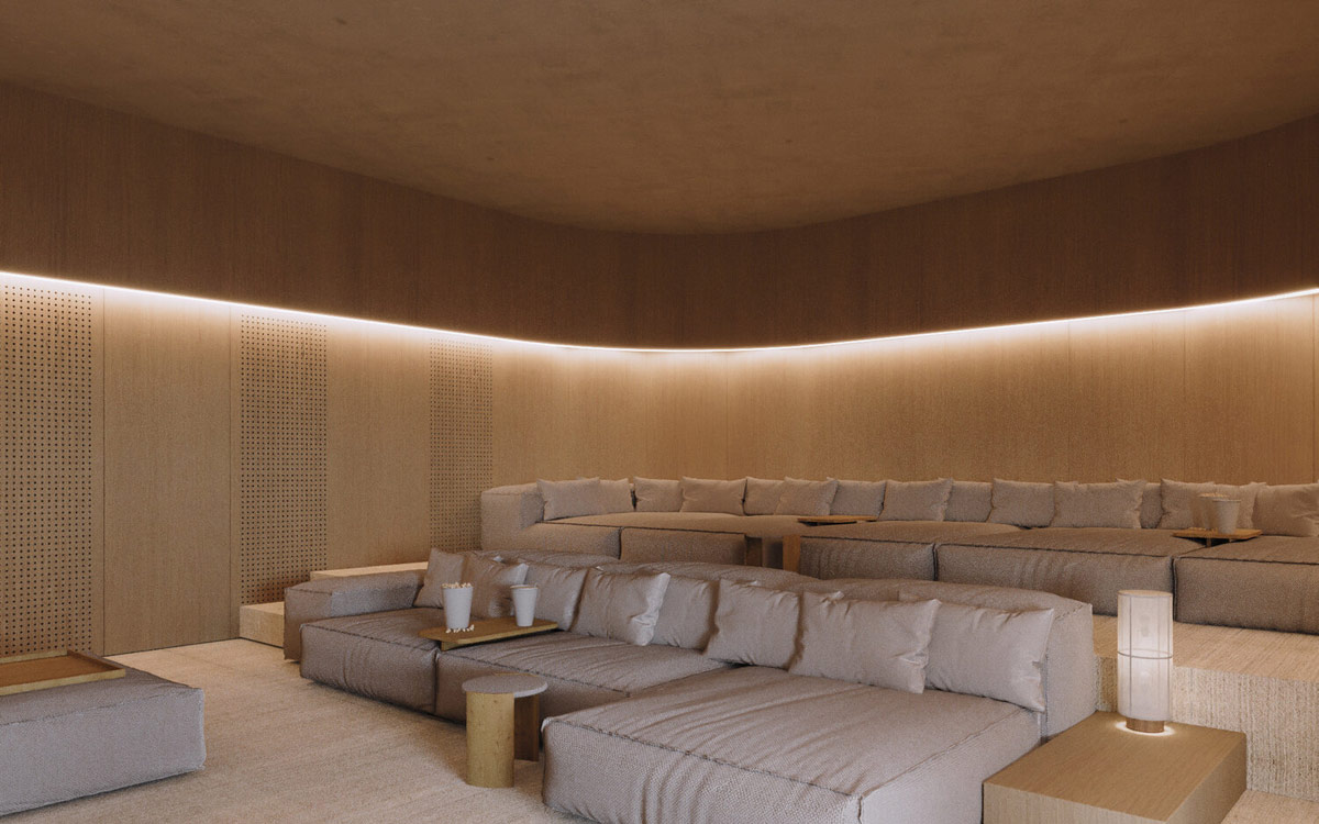 Hidden perimeter lighting paints a warm glow around the softly curved edges of the cinema space.