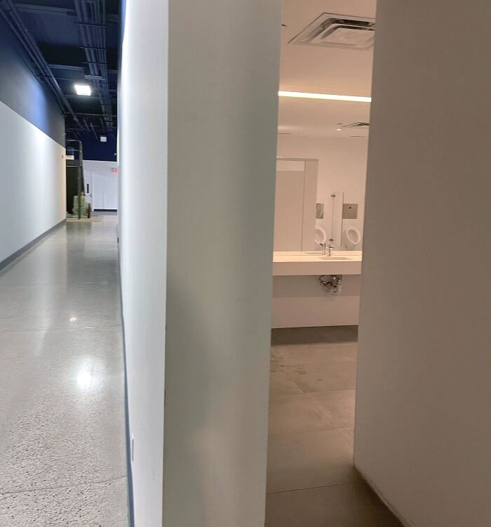 The Positioning Of The Mirror And Urinals In Our Office Building. This Is The Main Hallway